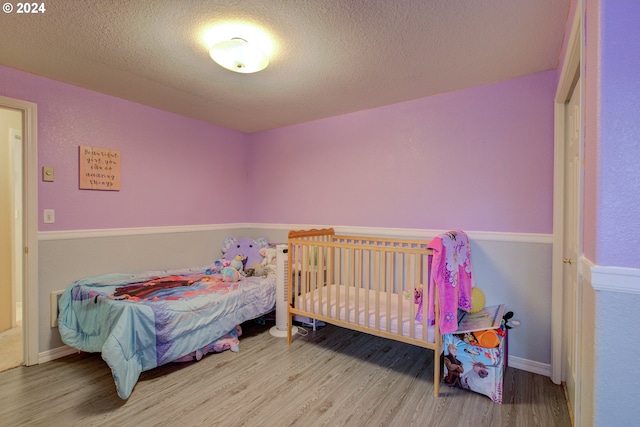 bedroom with hardwood / wood-style floors and a textured ceiling