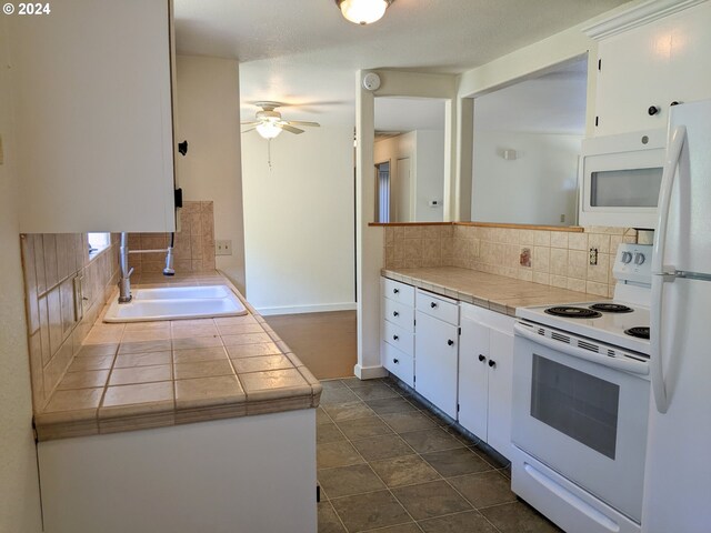 kitchen featuring backsplash, sink, white appliances, tile counters, and white cabinets