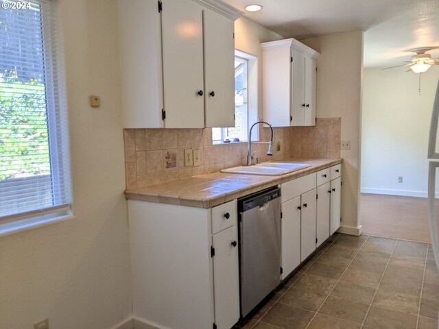 kitchen featuring sink, white cabinets, and dishwasher