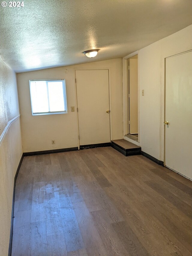 unfurnished room featuring a textured ceiling and hardwood / wood-style flooring