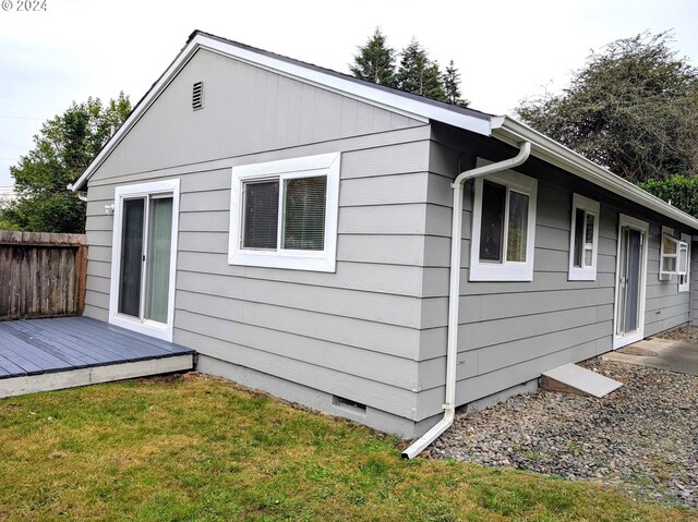 view of home's exterior featuring a deck and a yard