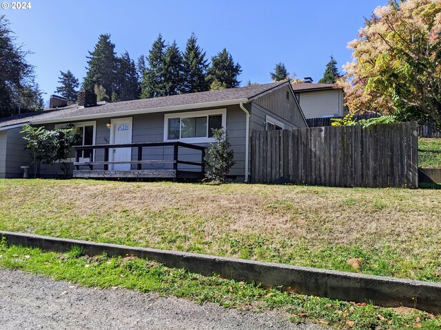 ranch-style home featuring a front yard and a deck