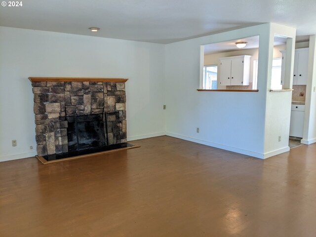 unfurnished living room featuring a stone fireplace