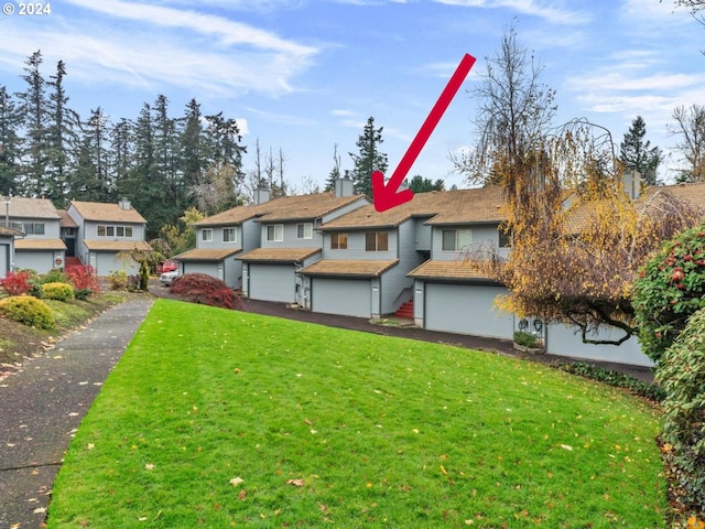 view of front of home with a front yard and a garage