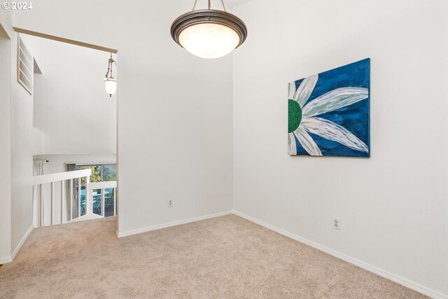 carpeted spare room featuring vaulted ceiling