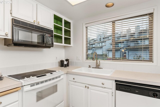 kitchen featuring white cabinetry, sink, and white appliances