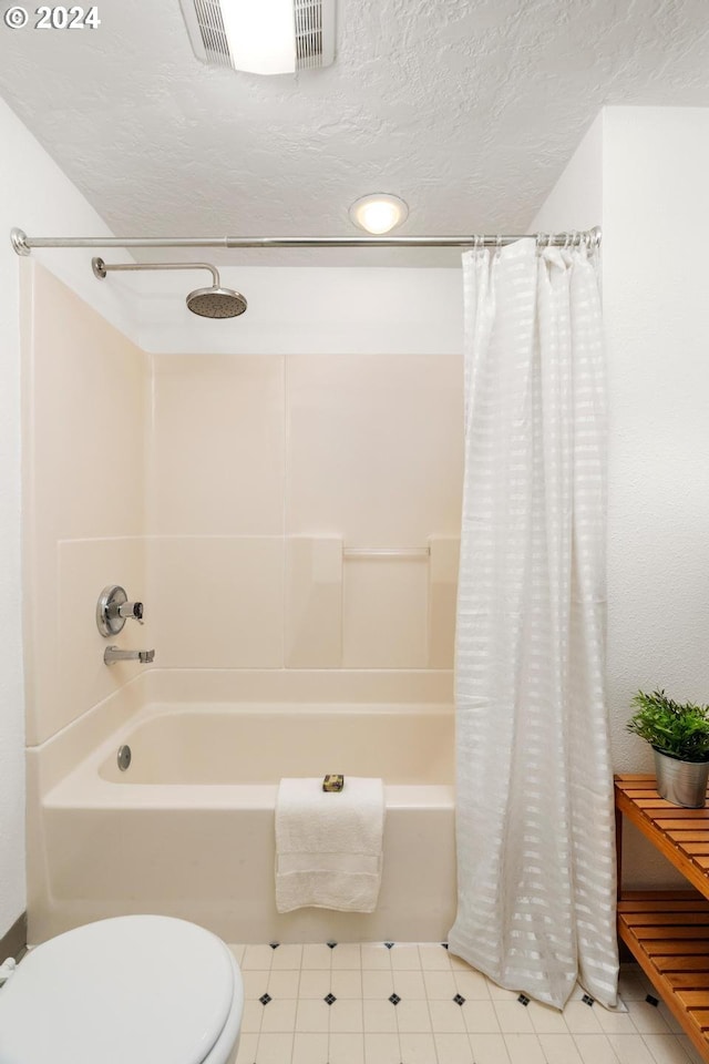 bathroom with a textured ceiling and shower / bathtub combination with curtain