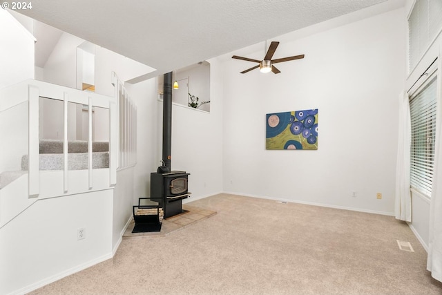 living room with ceiling fan and a wood stove