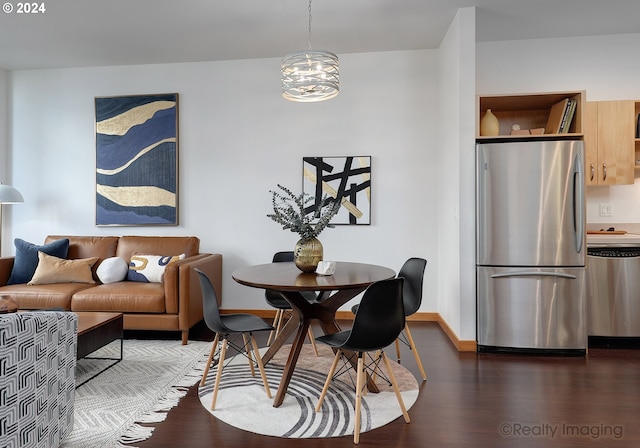 dining space featuring a notable chandelier, baseboards, and wood finished floors