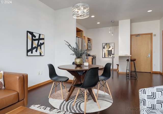 dining space featuring a notable chandelier, recessed lighting, wood finished floors, and baseboards