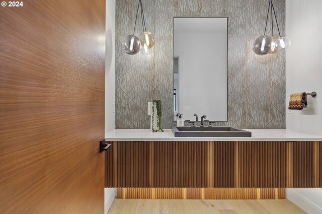 bathroom with hardwood / wood-style floors, vanity, and an inviting chandelier