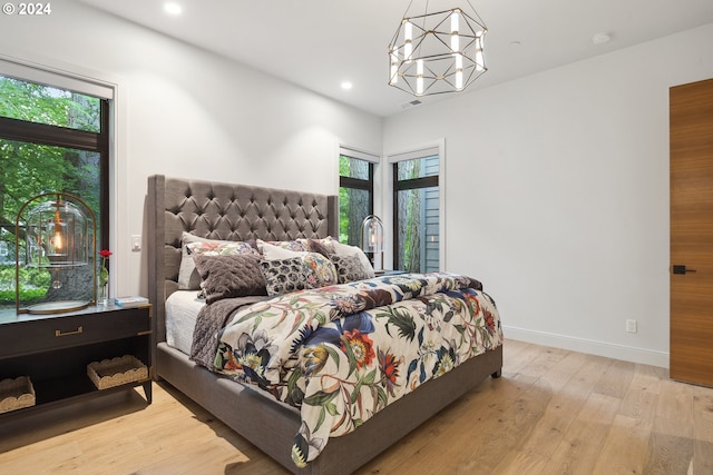 bedroom featuring light hardwood / wood-style floors and an inviting chandelier