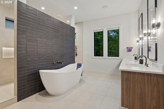 bathroom featuring tile patterned floors, vanity, tile walls, and independent shower and bath