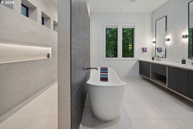 bathroom featuring tile patterned flooring, vanity, a bathtub, and tile walls