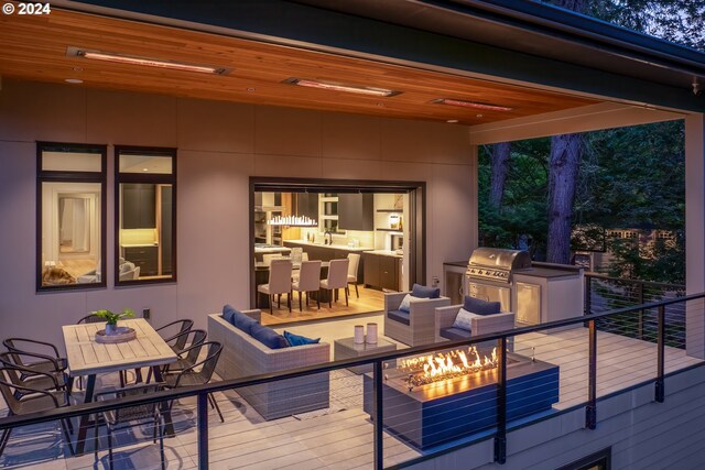 wooden terrace featuring grilling area, outdoor lounge area, and an outdoor kitchen