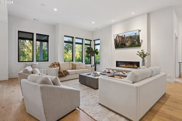 13581 Goodall Rd, Lake Oswego, OR 97034 - living room featuring recessed lighting, light wood-style flooring, a glass covered fireplace, and baseboards