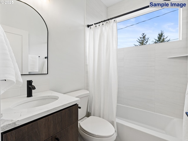 bathroom featuring toilet, shower / bath combo with shower curtain, and vanity