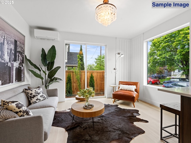 living area with an AC wall unit, wood finished floors, and a chandelier