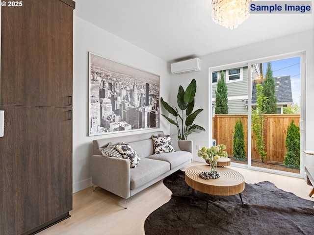 living area featuring a wall mounted AC, light wood-type flooring, and a chandelier