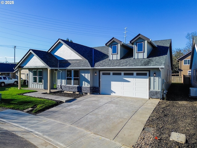 view of front of house with a garage, board and batten siding, concrete driveway, and fence