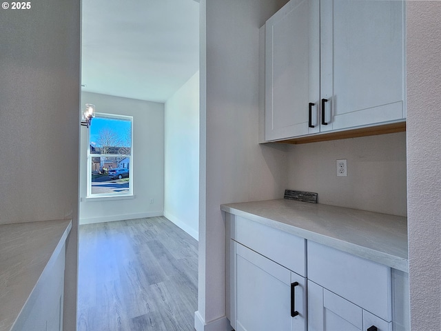 bar featuring baseboards and light wood-style flooring