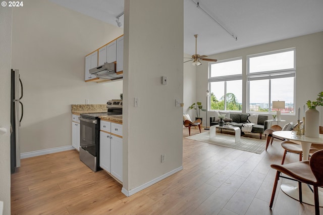 kitchen with track lighting, light stone countertops, ceiling fan, white cabinets, and stainless steel range with electric cooktop