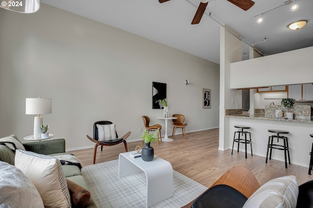 living room with ceiling fan and light wood-type flooring