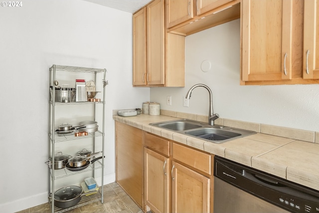 kitchen with light brown cabinetry, sink, tile counters, and stainless steel dishwasher