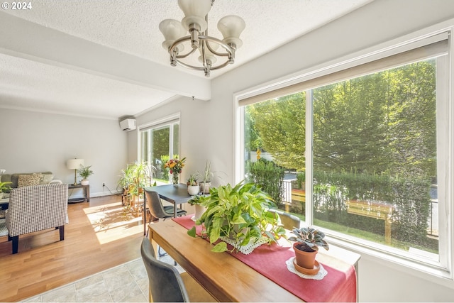 dining room with a wall mounted air conditioner, beam ceiling, a textured ceiling, and light wood-type flooring