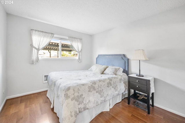 bedroom with hardwood / wood-style floors and a textured ceiling