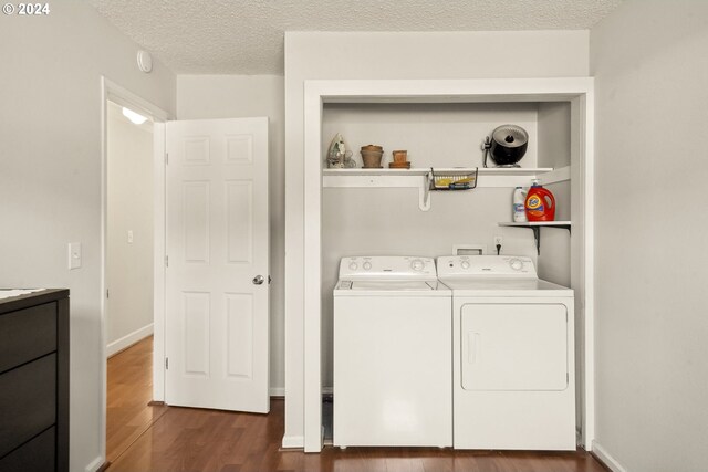 laundry room featuring dark hardwood / wood-style floors, a textured ceiling, and independent washer and dryer