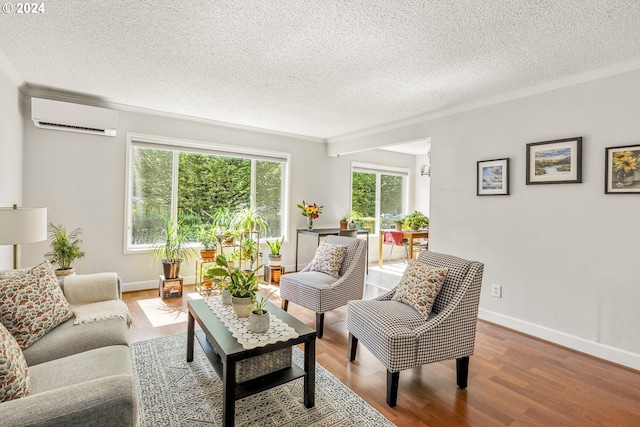 sitting room with a textured ceiling, wood-type flooring, ornamental molding, and a wall mounted AC