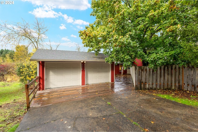 garage with fence and aphalt driveway