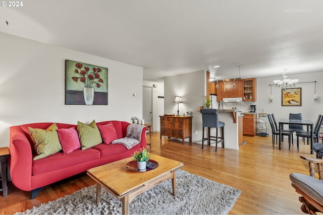 living area featuring light wood-type flooring and a notable chandelier