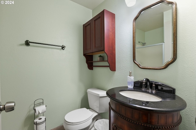 bathroom with vanity, a shower, and toilet