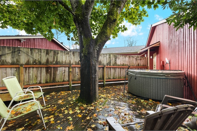 view of yard featuring cooling unit, a hot tub, fence, and a deck