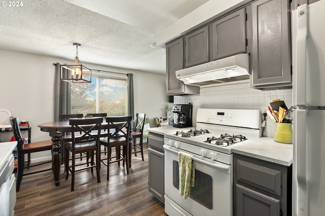 kitchen with a chandelier, gray cabinets, under cabinet range hood, and white appliances