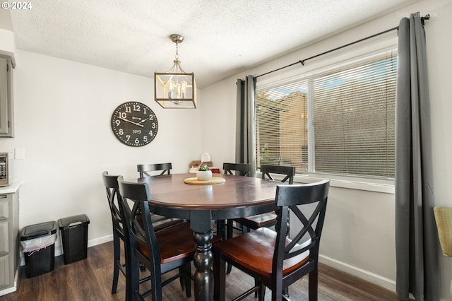 dining space featuring baseboards, an inviting chandelier, a textured ceiling, and dark wood finished floors