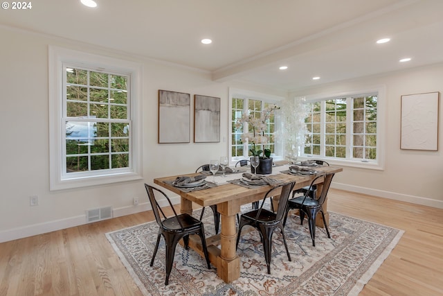 dining space with light hardwood / wood-style flooring and crown molding