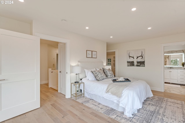 bedroom with ensuite bathroom and light hardwood / wood-style floors