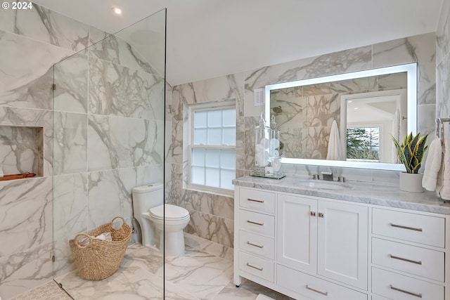 bathroom featuring vanity, tile walls, and toilet