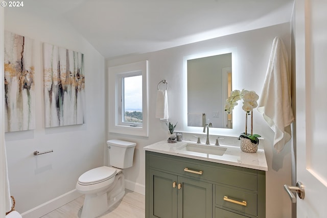 bathroom featuring vanity, vaulted ceiling, and toilet