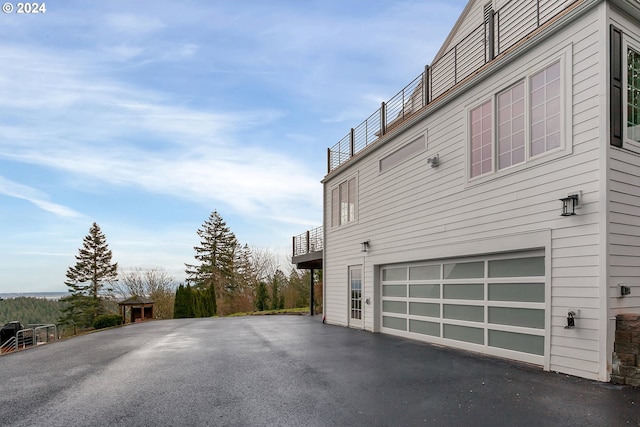 view of side of property featuring a garage and a balcony