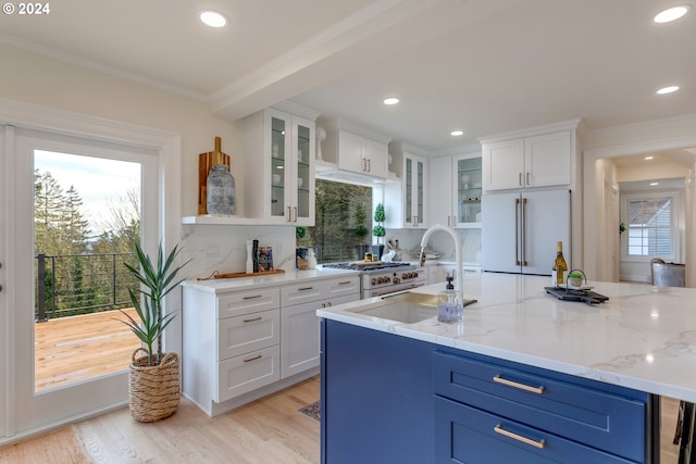 kitchen featuring sink, light stone counters, light hardwood / wood-style flooring, high end white refrigerator, and white cabinets