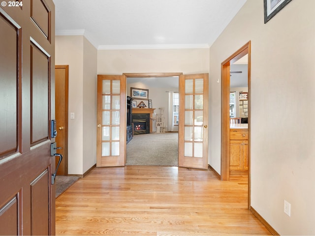 entryway featuring ornamental molding, light hardwood / wood-style flooring, and french doors