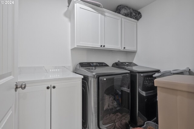 laundry area featuring cabinets and washing machine and clothes dryer