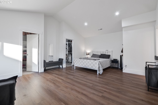 bedroom with a closet, a spacious closet, dark hardwood / wood-style flooring, and high vaulted ceiling