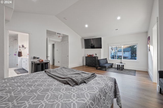 bedroom with wood-type flooring, ensuite bathroom, and vaulted ceiling