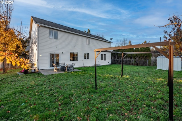 back of property featuring a shed, a yard, and a patio