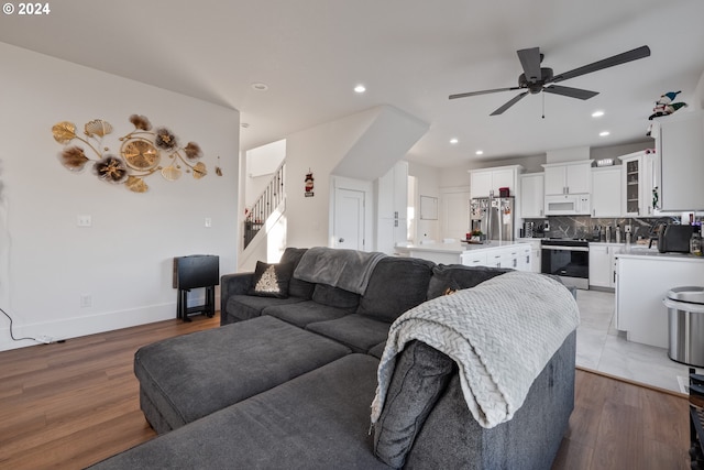 living room featuring light wood-type flooring and ceiling fan